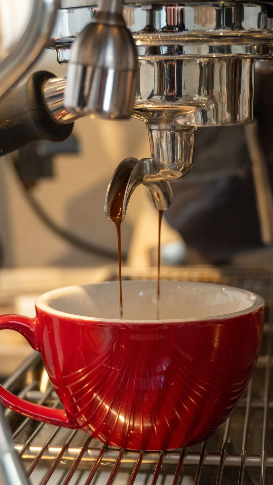Espresso pouring into a red cup